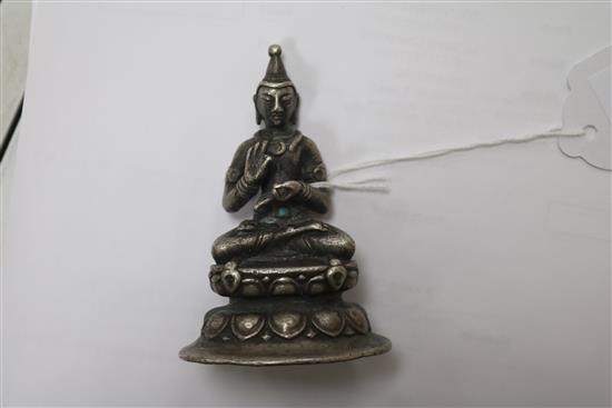 A white metal Buddha